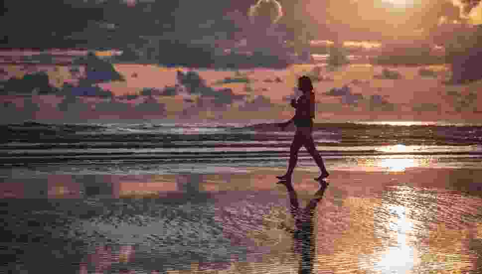 Silhouette of walking person on seashore 3308743